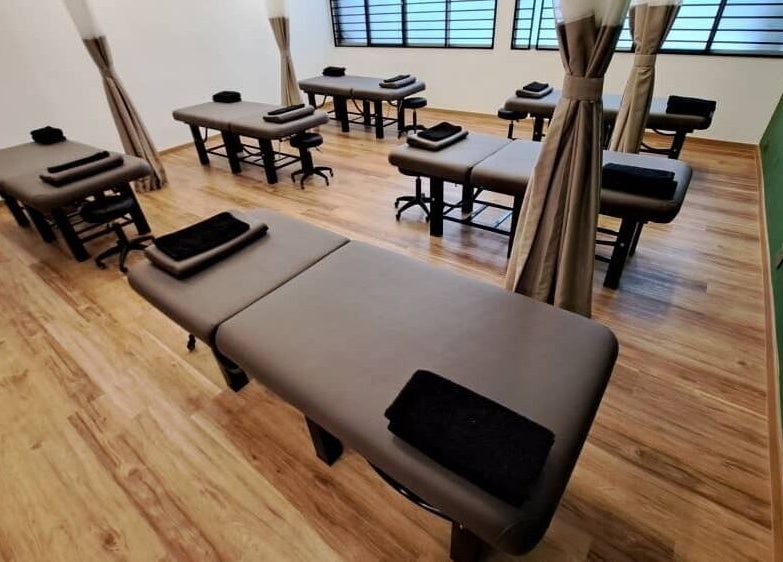 Calm massage room at The Flexologist, Kuala Lumpur, Wilayah Persekutuan Kuala Lumpur, MY, featuring multiple tables.