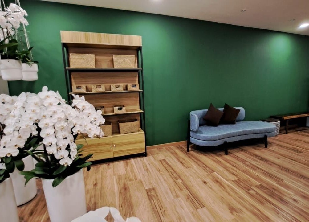 Relaxing lounge area at The Flexologist, Kuala Lumpur, featuring orchids and cozy seating.