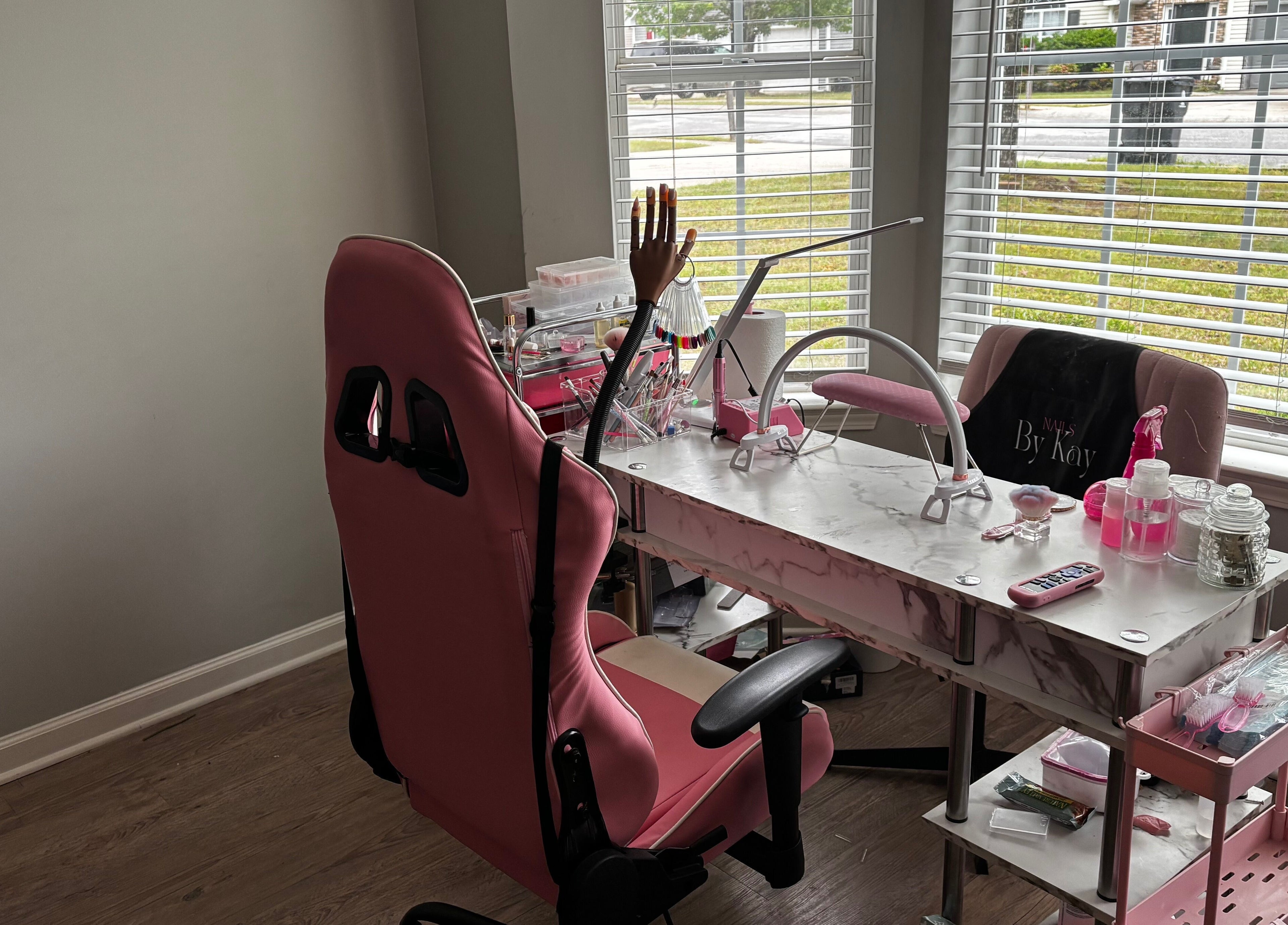 Modern nail station at Nails By Kay, Villa Rica, Georgia, US, featuring pink chairs and a marble table.