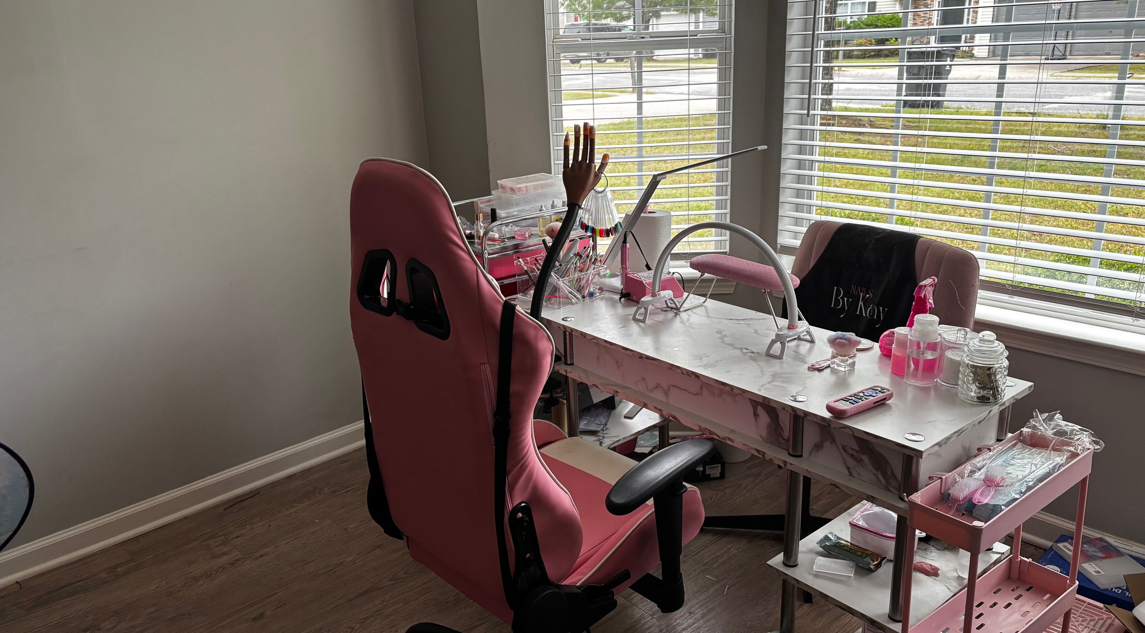 Modern nail station at Nails By Kay, Villa Rica, Georgia, US, featuring pink chairs and a marble table.