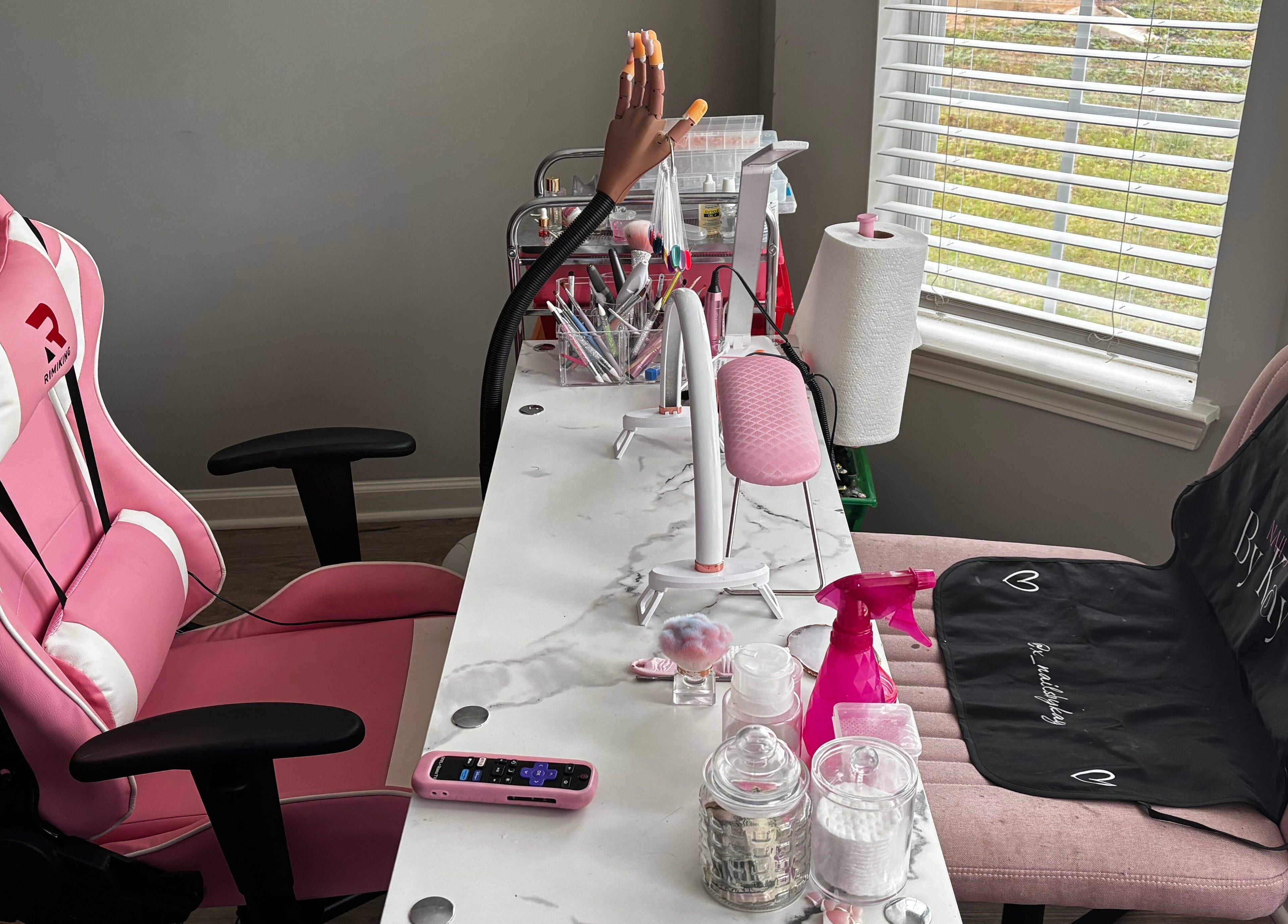Nails By Kay, Villa Rica, Georgia - a stylish nail station with pink decor and nail tools by the window.