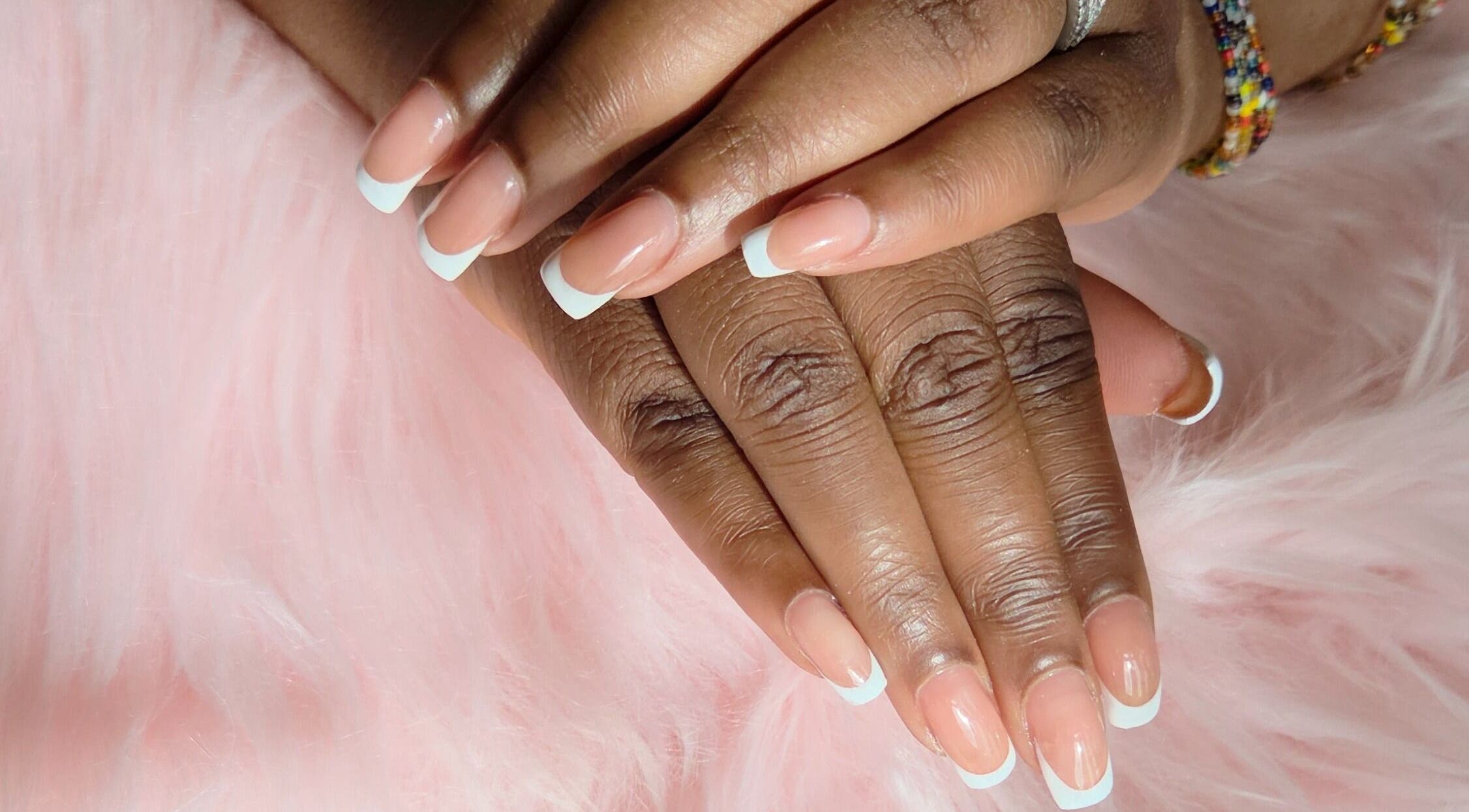 Elegant French manicure by Fab Nails - Mobile Nail Services, Newcastle upon Tyne, England, GB, on a soft pink background.