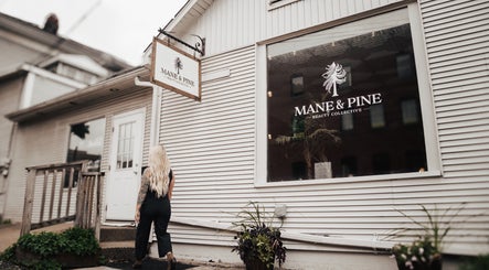 Woman entering Mane & Pine (Laurie Gurr Beauty) in East Aurora, New York, US, showcasing modern salon exterior.