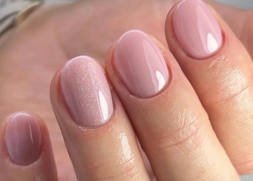 Elegant glossy pink manicure at The Beauty Barn, Wilton, England, GB, highlighting nail care expertise.