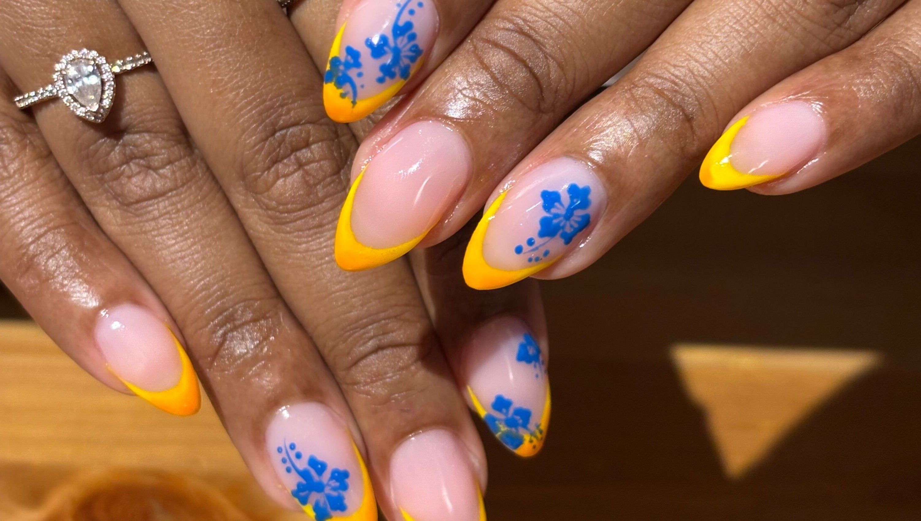 Design d'ongles vibrant avec des motifs bleus et jaunes chez Le Saphyr, Montréal, Québec, CA.