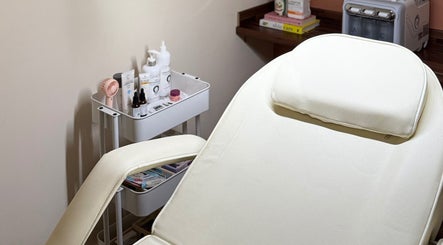 Elegant treatment room at KM Skin, Clydebank, Scotland, GB, featuring a plush reclining chair and skincare products.