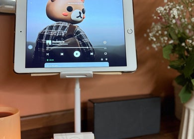 Tablet at KM Skin Clydebank, Scotland, GB playing music surrounded by flowers and candles.