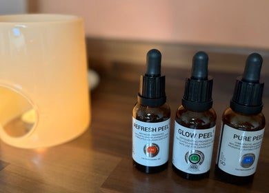 Skincare treatment bottles at KM Skin, Clydebank, Scotland, GB, displayed with candle holder.