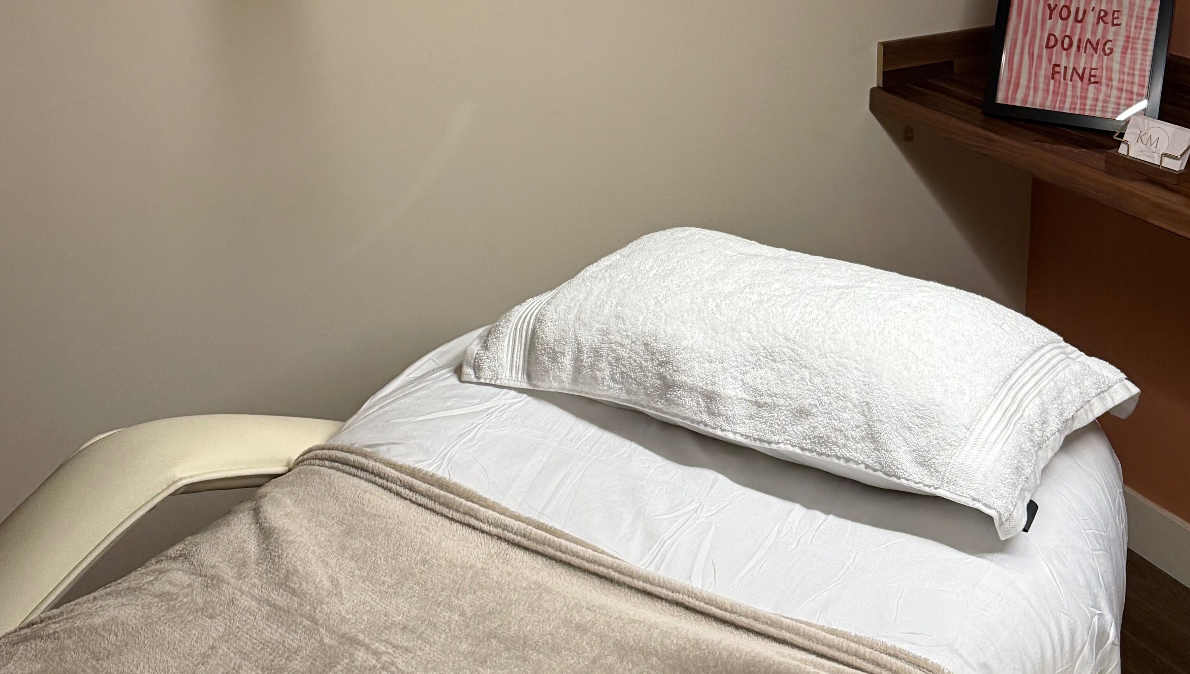 Comfortable treatment bed at KM Skin, Clydebank, Scotland, GB. Inviting ambience for relaxing wellness sessions.