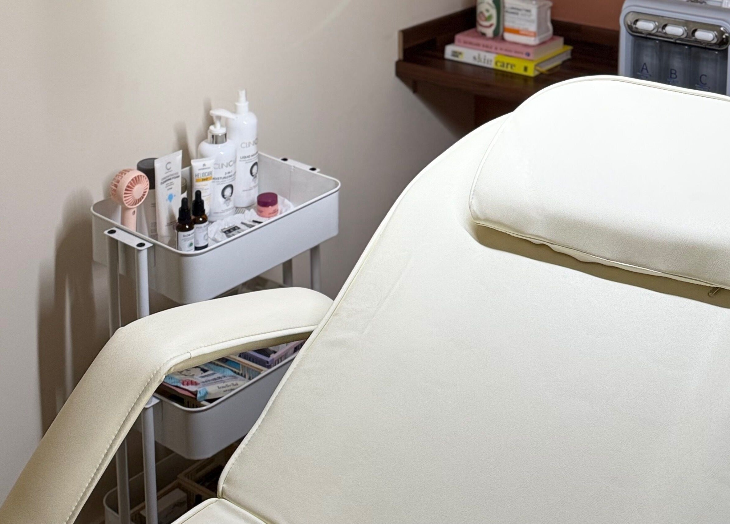 Calm treatment room at KM Skin in Clydebank, Scotland, GB, featuring a comfortable spa bed and skincare products.