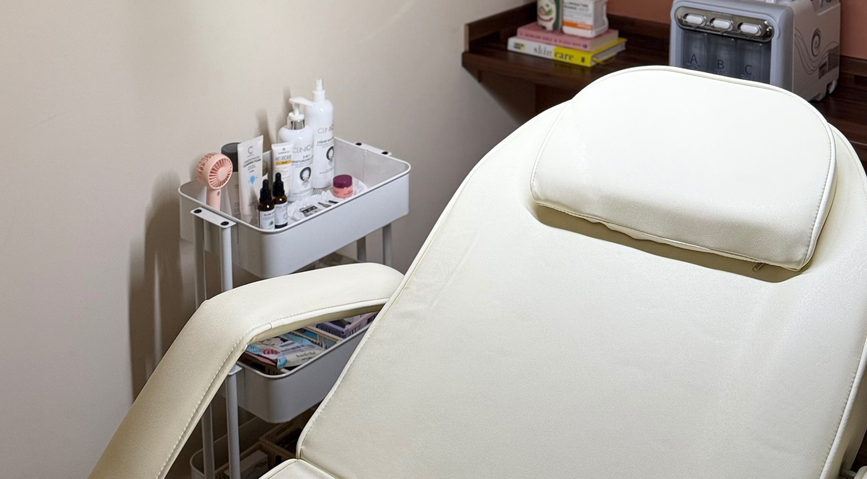 Calm treatment room at KM Skin in Clydebank, Scotland, GB, featuring a comfortable spa bed and skincare products.