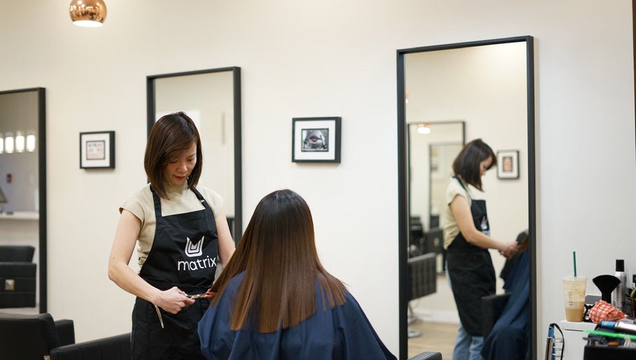 Stylist at Thi Vo Hair Salon in Calgary, Alberta, CA, expertly cutting a client's hair.