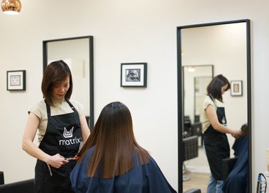 Stylist at Thi Vo Hair Salon in Calgary, Alberta, CA, expertly cutting a client's hair.
