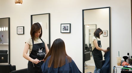 Stylist at Thi Vo Hair Salon in Calgary, Alberta, CA, expertly cutting a client's hair.
