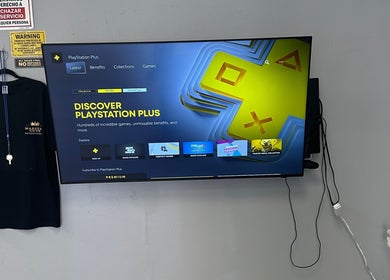 PlayStation Plus screen and Maestro Cuts Barbershop shirt in van nuys, California, US.