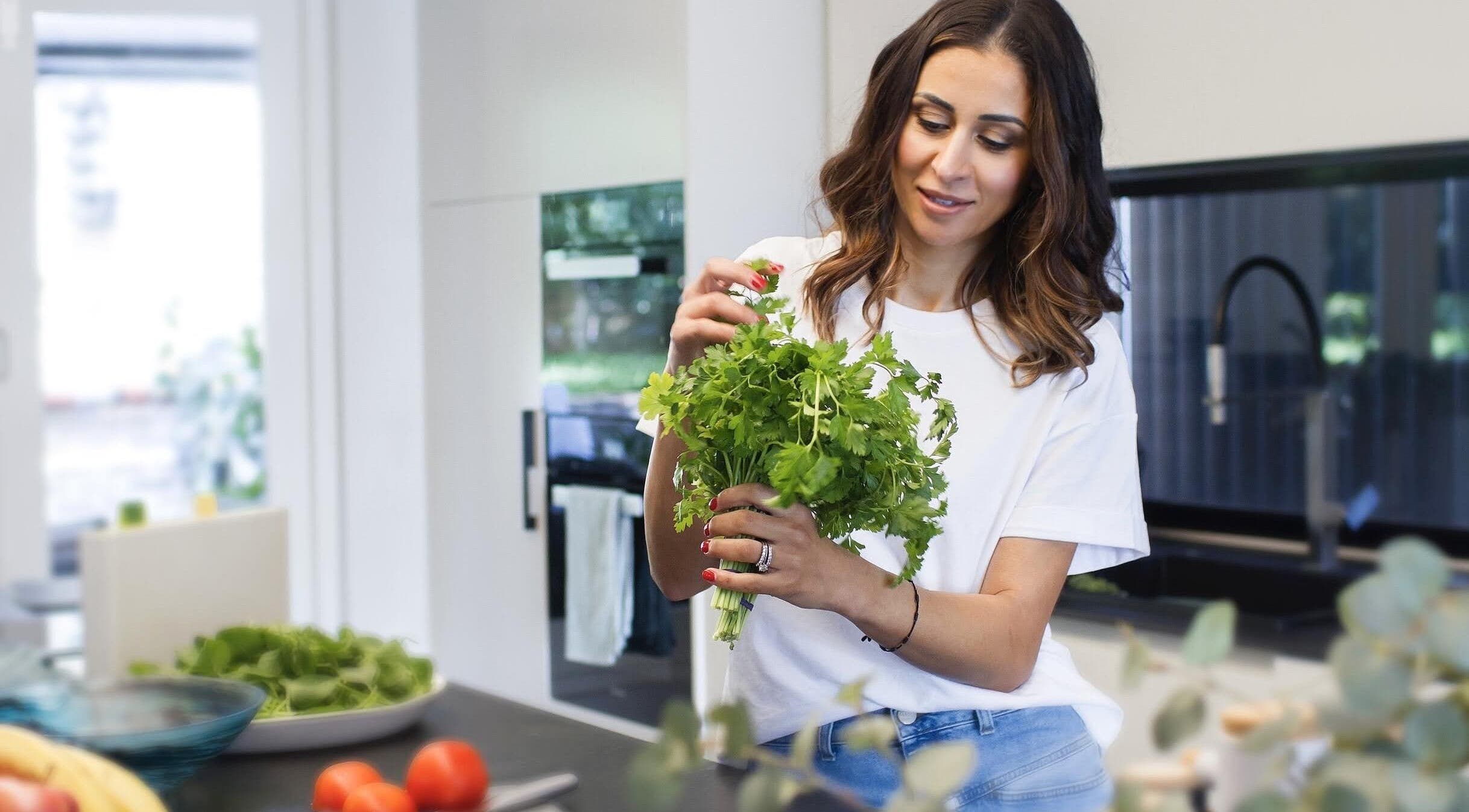 A person preparing fresh herbs in a kitchen at Transcend Nutrition, Rodd Point, New South Wales, AU.