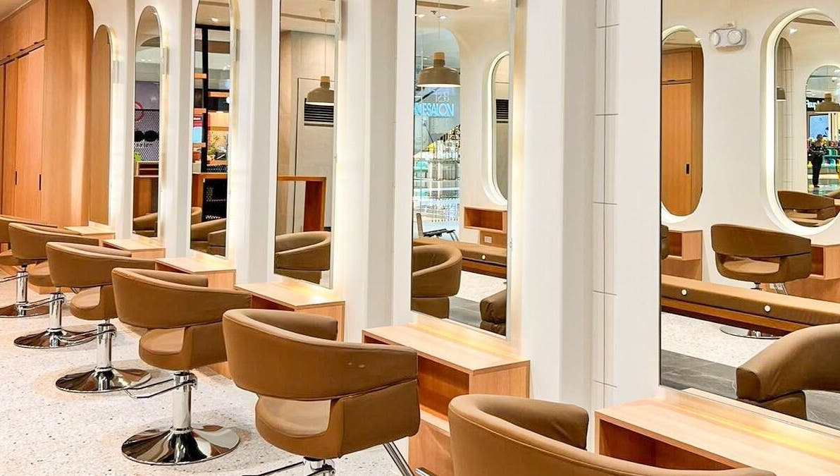 Modern salon interior at Azta Urban Salon - One Ayala, Makati, Metro Manila, PH with sleek styling chairs and mirrors.