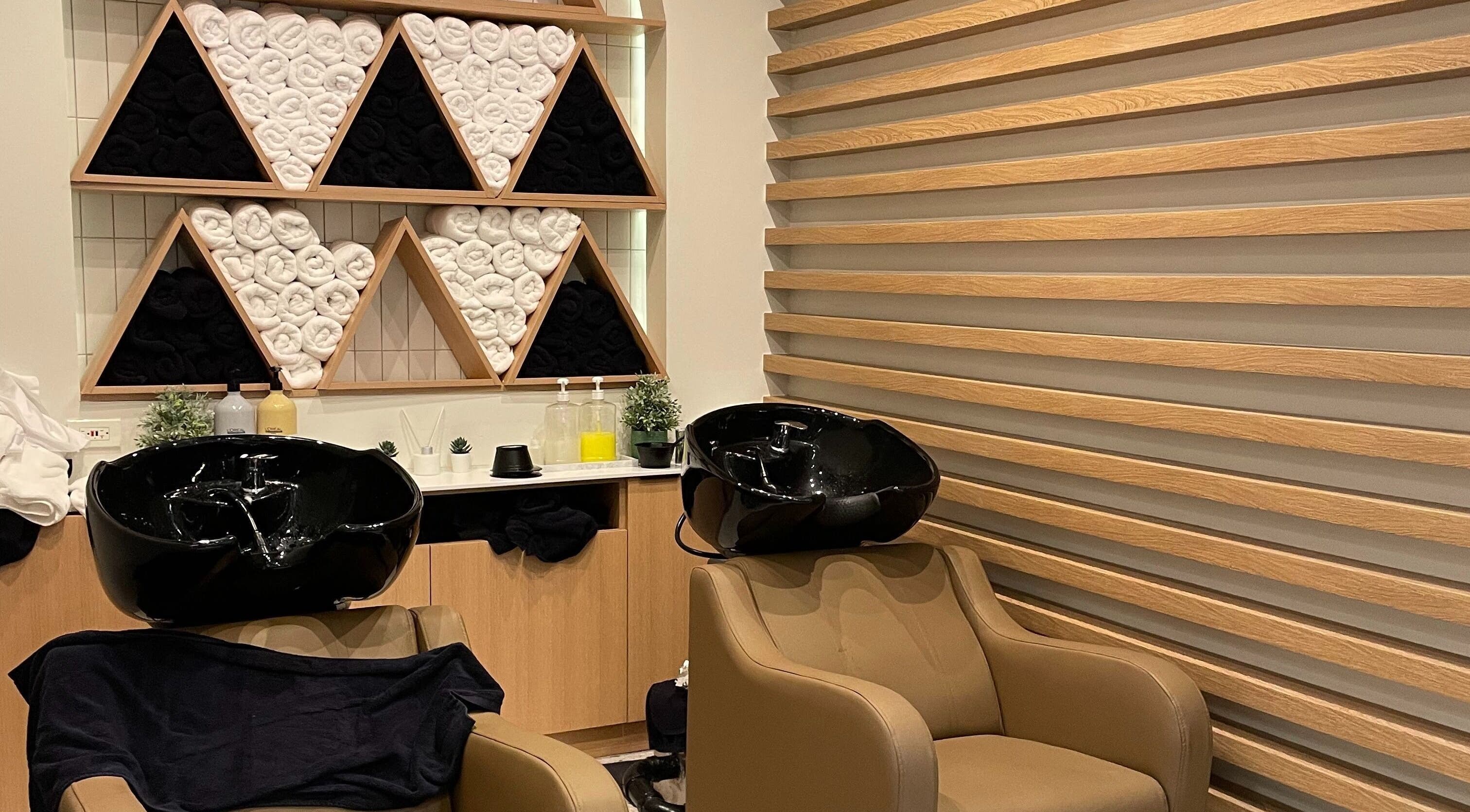 Relaxing wash area at Azta Urban Salon - One Ayala, Makati, Metro Manila, PH with plush chairs and stylish decor.