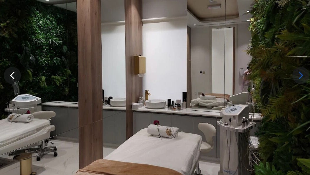 Relaxing spa room at The Blonde Luxury Salon Khalifa City, Abu Dhabi, AE with lush greenery and treatment bed.