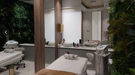 Relaxing spa room at The Blonde Luxury Salon Khalifa City, Abu Dhabi, AE with lush greenery and treatment bed.