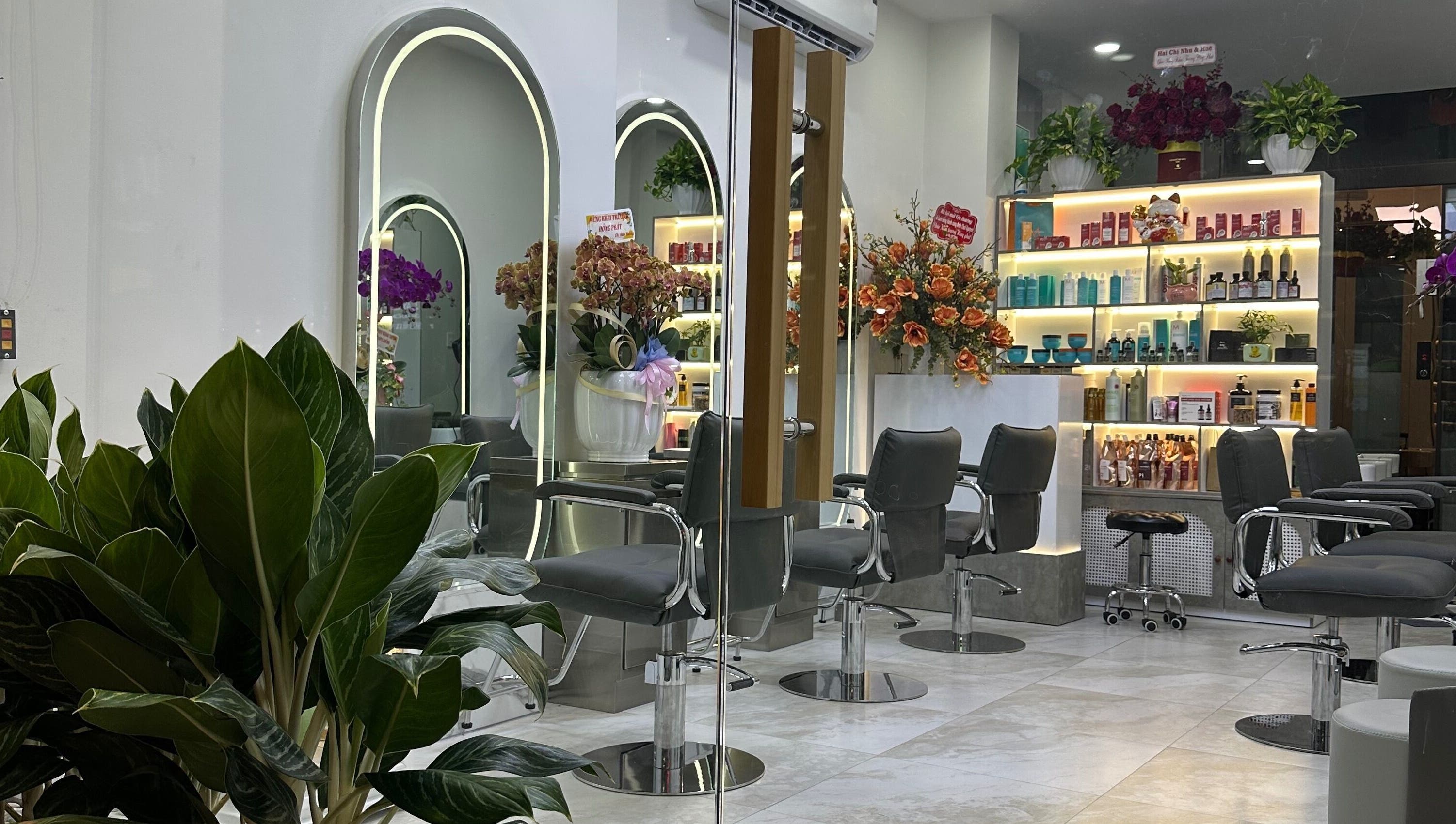 Interior of The Beauty Salon By Andy, Hồ Chí Minh, featuring elegant styling stations and lush greenery.