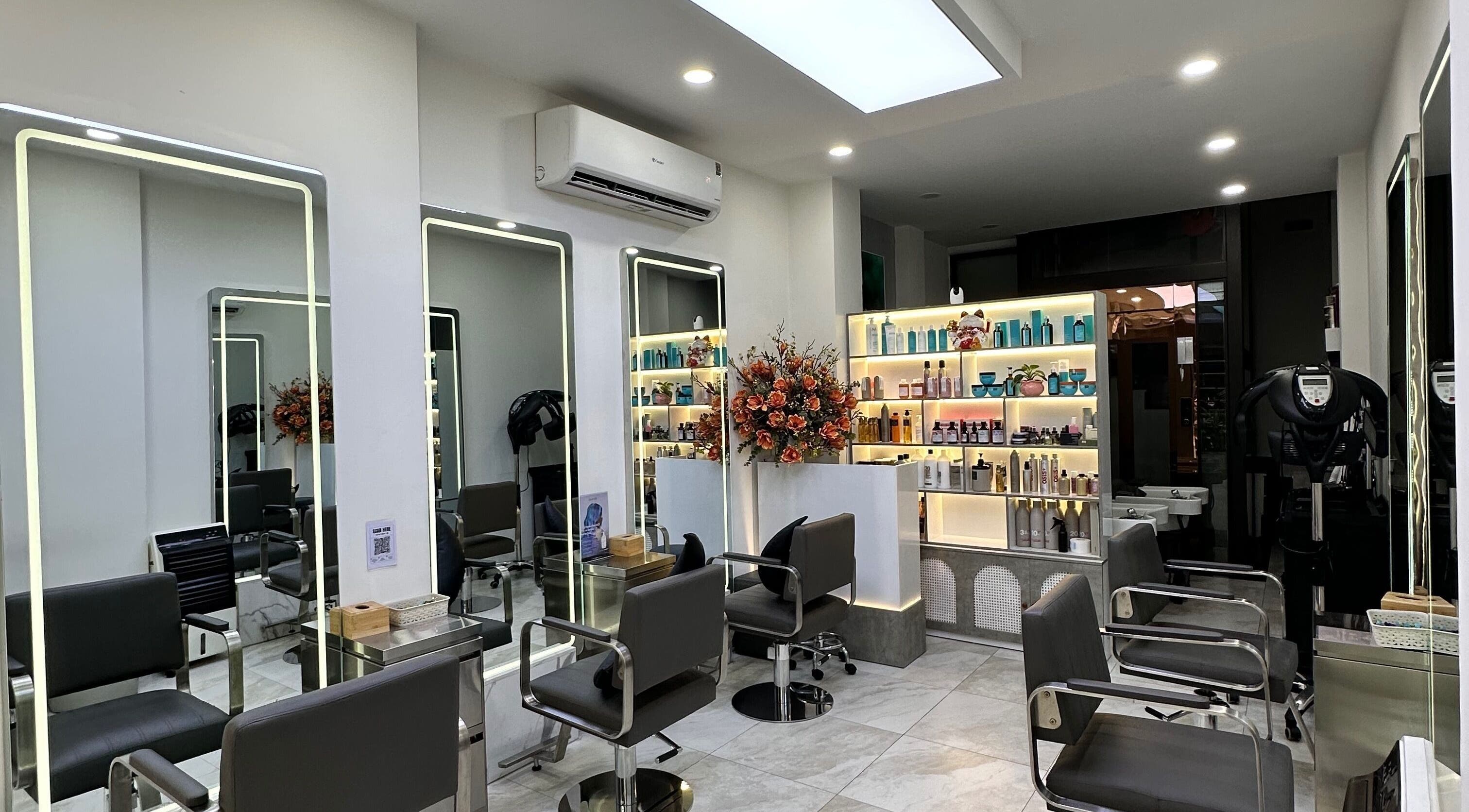 Sleek salon interior at The Beauty Salon By Andy, Hồ Chí Minh, featuring modern chairs and product displays.