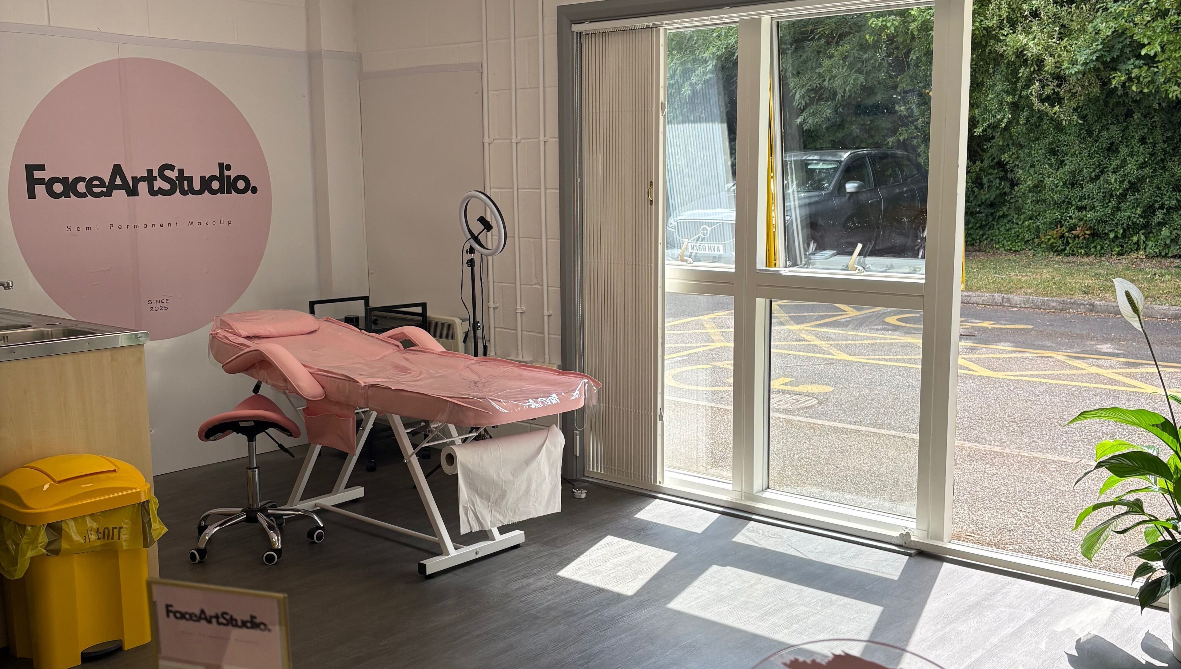 Relaxing interior of Face Art Studio, Hersden, England, featuring a pink treatment bed and large window view.