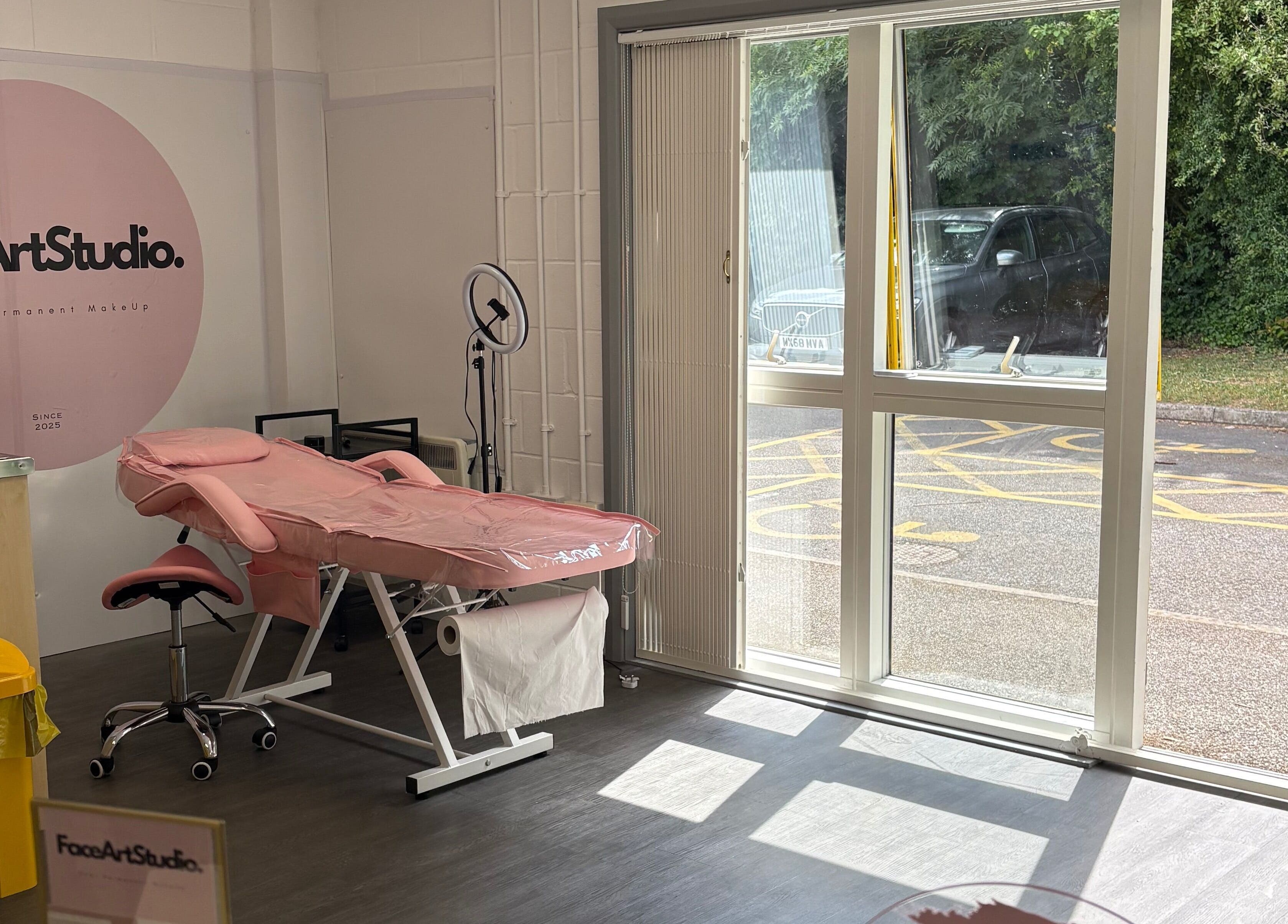 Relaxing interior of Face Art Studio, Hersden, England, featuring a pink treatment bed and large window view.