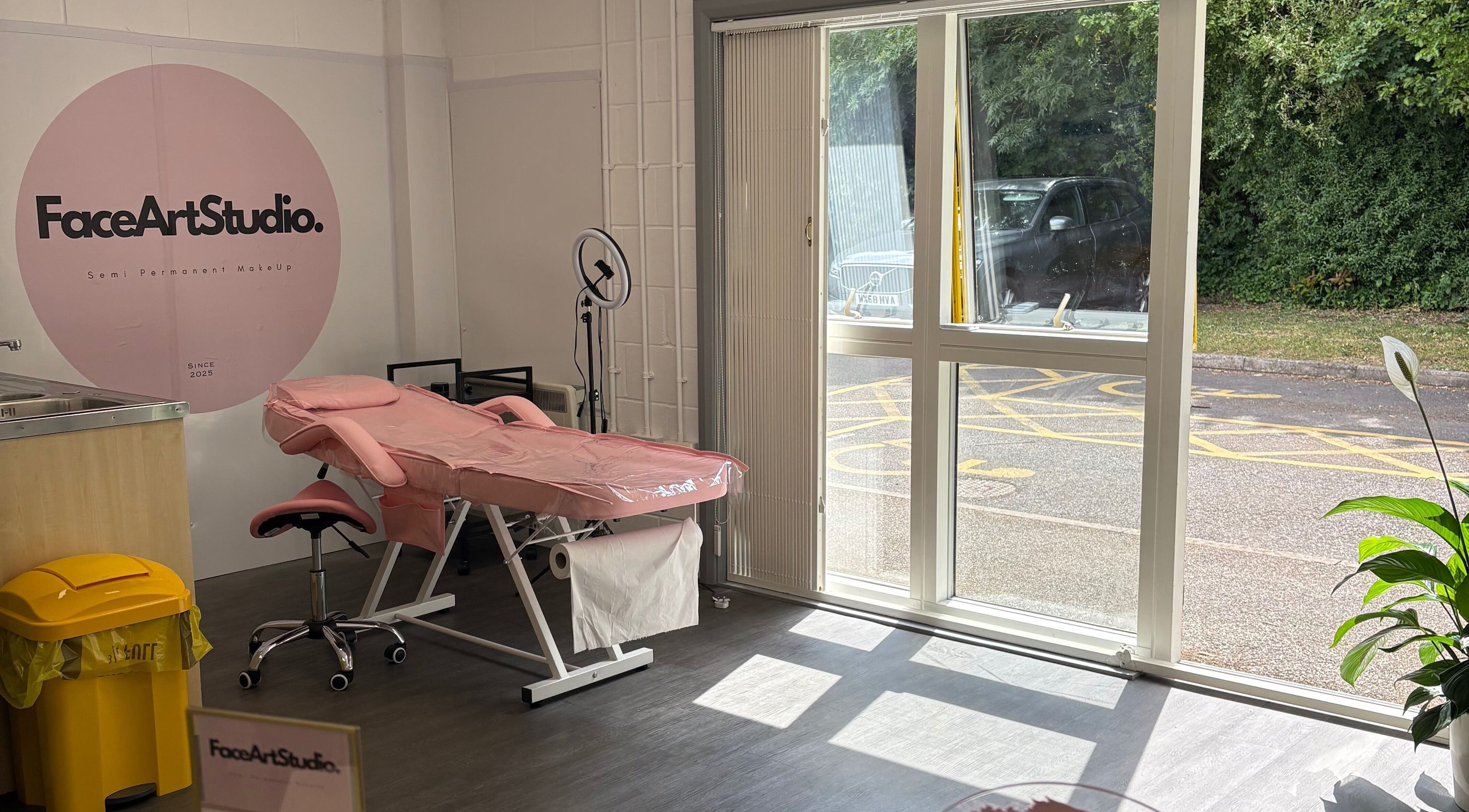 Relaxing interior of Face Art Studio, Hersden, England, featuring a pink treatment bed and large window view.
