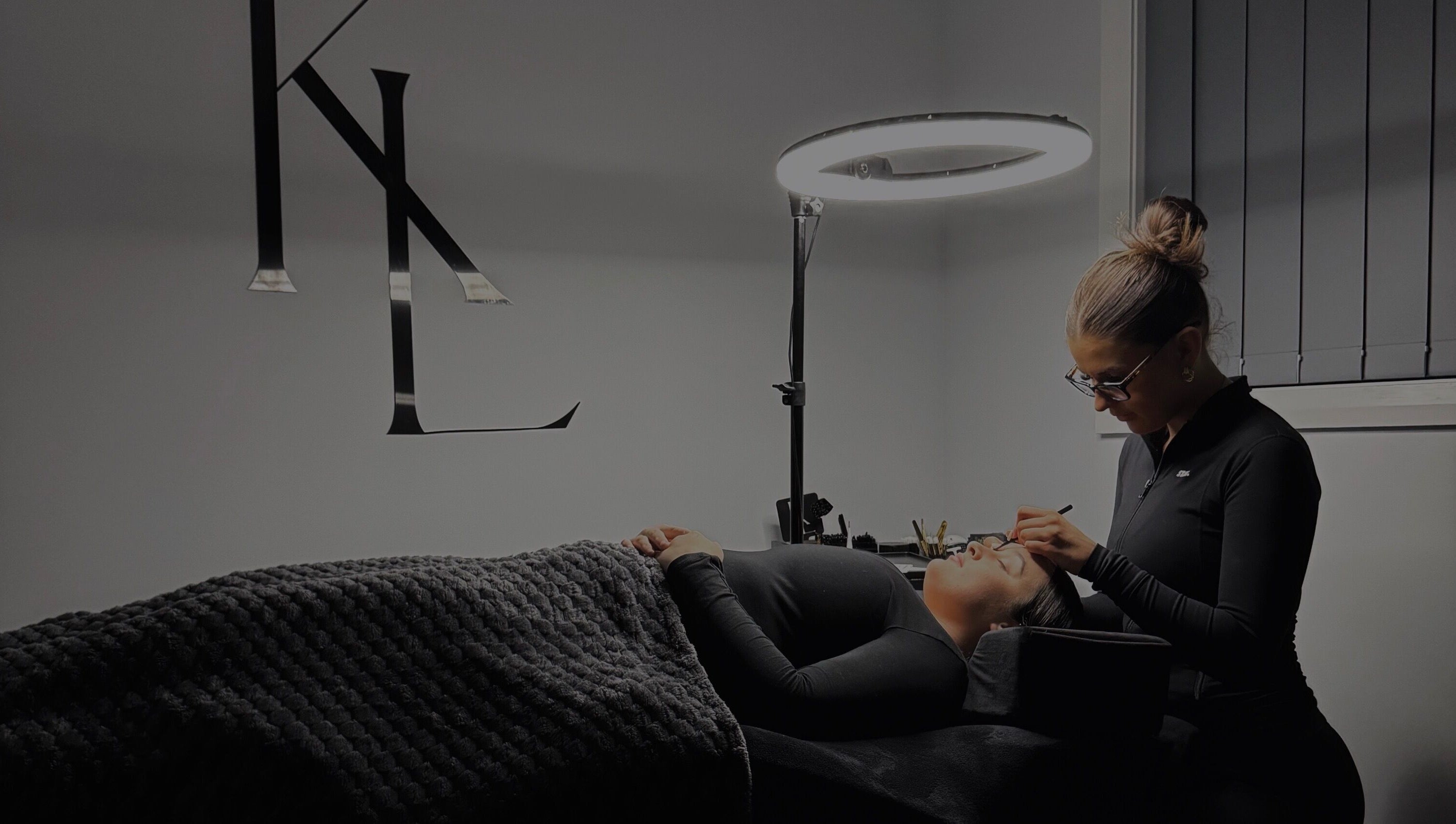 Expert applying eyelash extensions at LASHES BY KL in Tahmoor, New South Wales, AU under soft lighting.