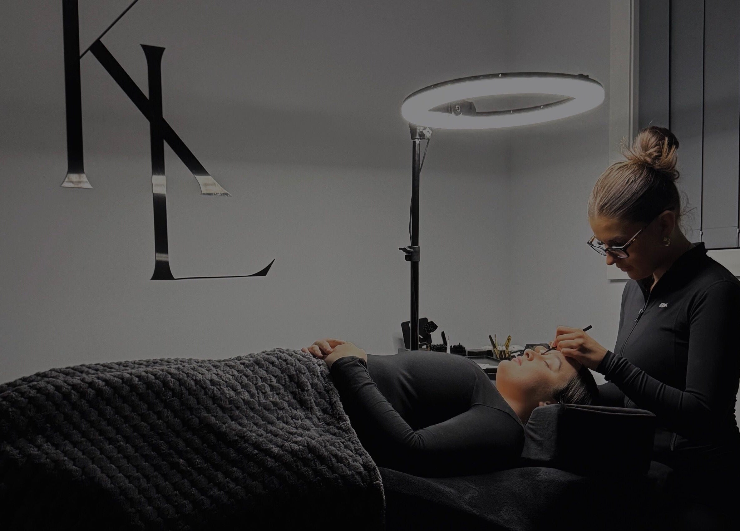 Expert applying eyelash extensions at LASHES BY KL in Tahmoor, New South Wales, AU under soft lighting.