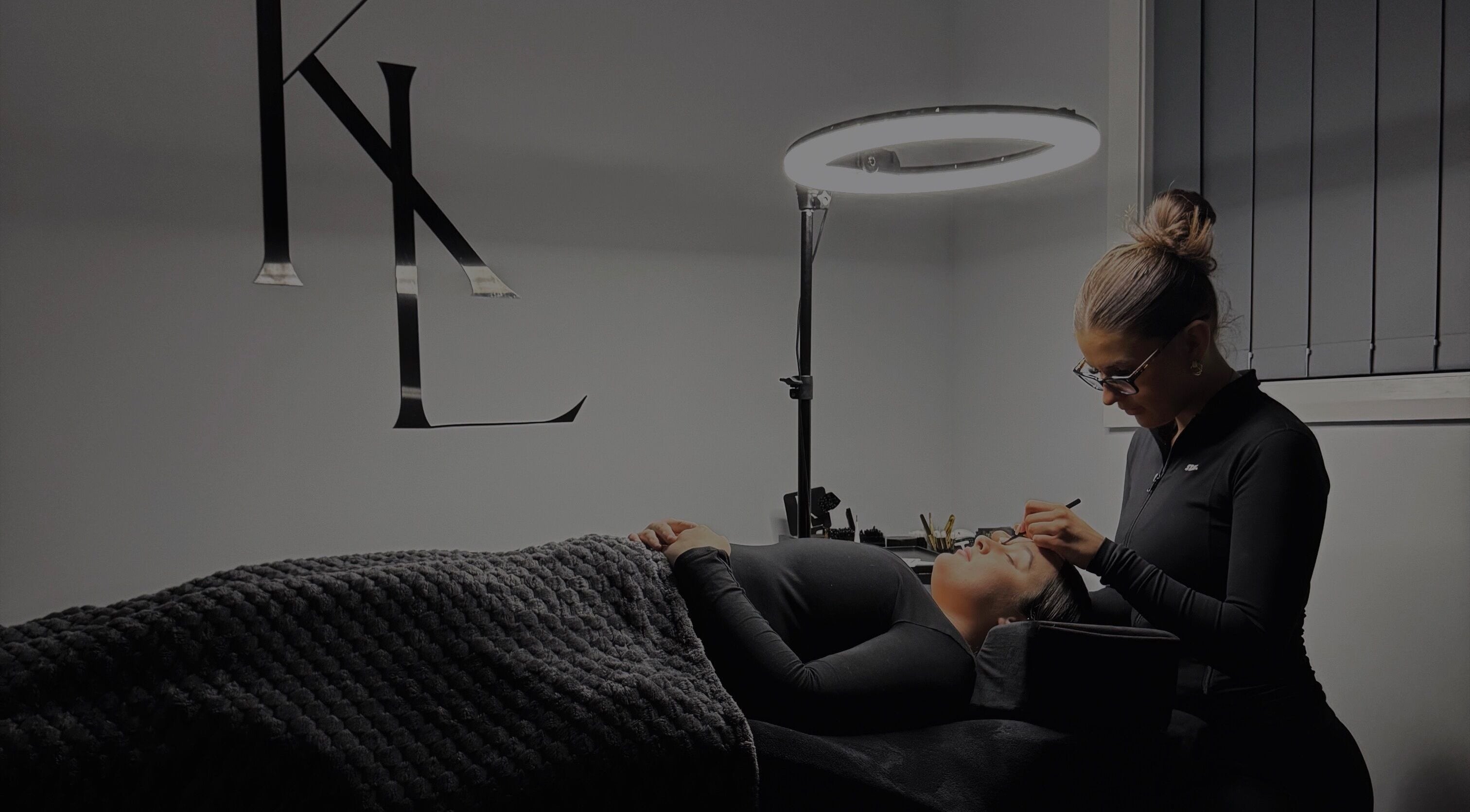 Expert applying eyelash extensions at LASHES BY KL in Tahmoor, New South Wales, AU under soft lighting.