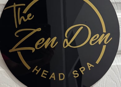 Elegant black and gold logo of The Zen Den Ltd. in Roseau, Saint George Parish, DM.