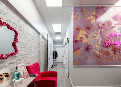 Stylish room at Eye Candy Lash and Brow Bar, Sarasota, Florida, US, with pink decor and neon art.