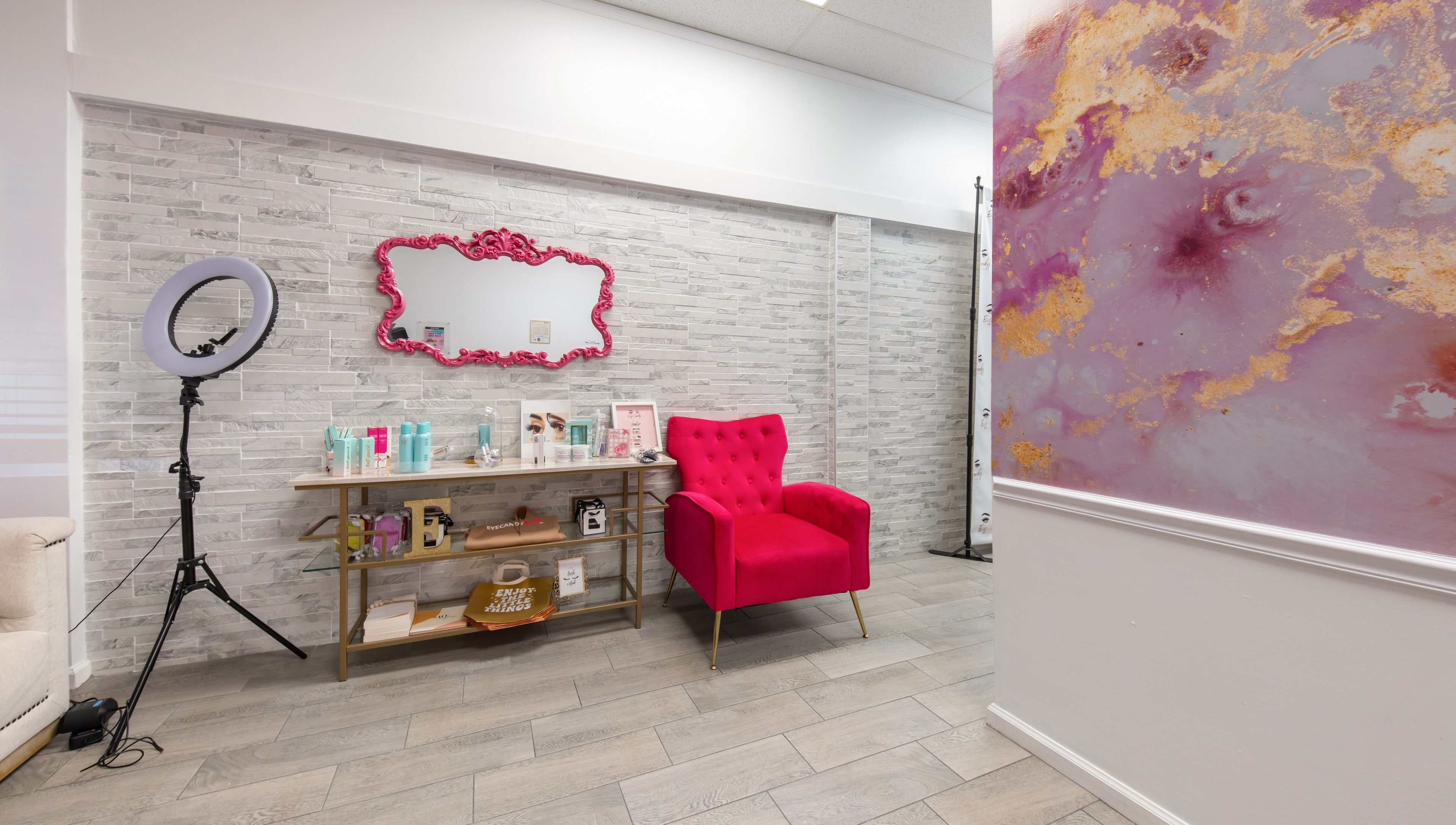 Chic glam corner at Eye Candy Lash and Brow Bar, Sarasota, Florida, US with a pink chair and mirror.