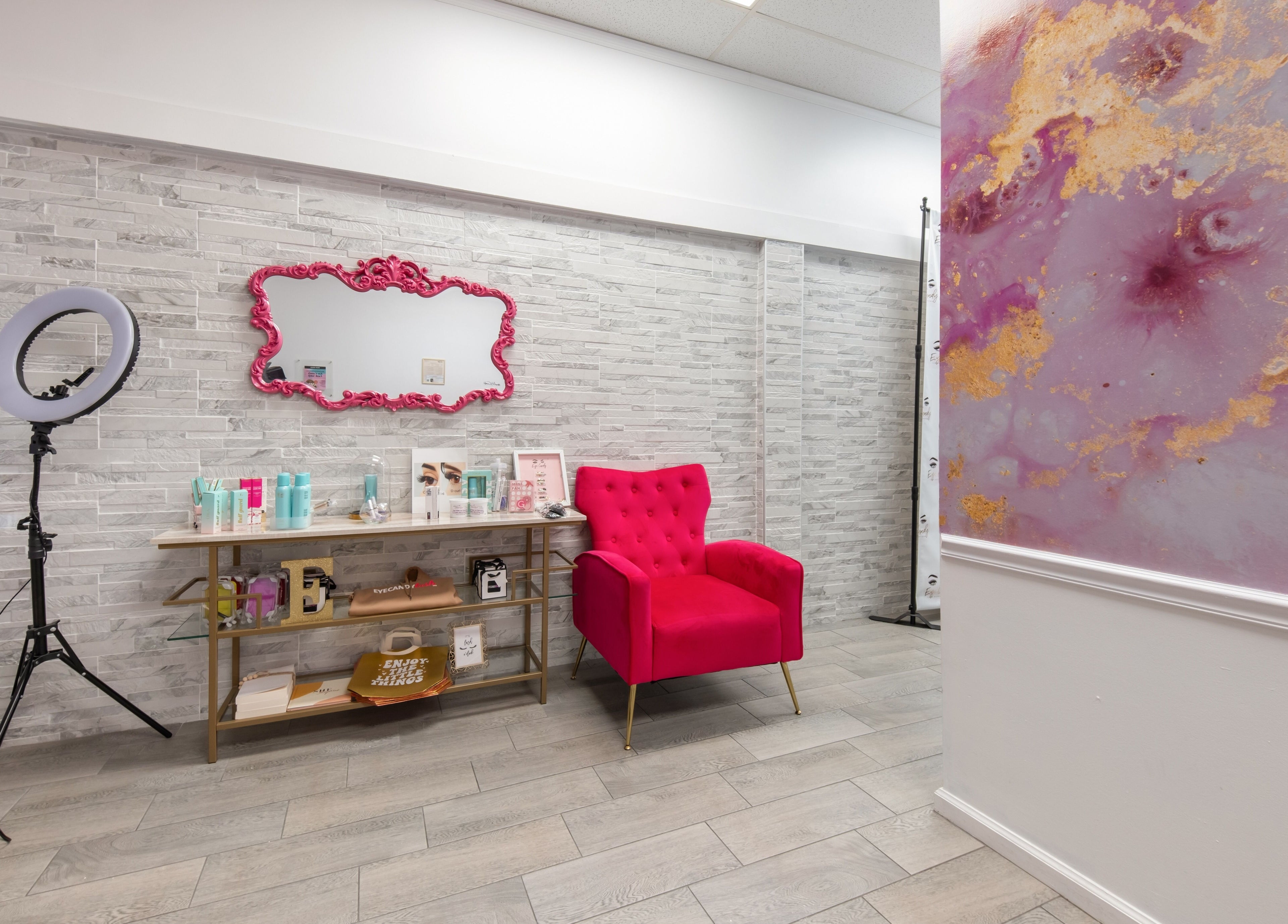 Chic glam corner at Eye Candy Lash and Brow Bar, Sarasota, Florida, US with a pink chair and mirror.