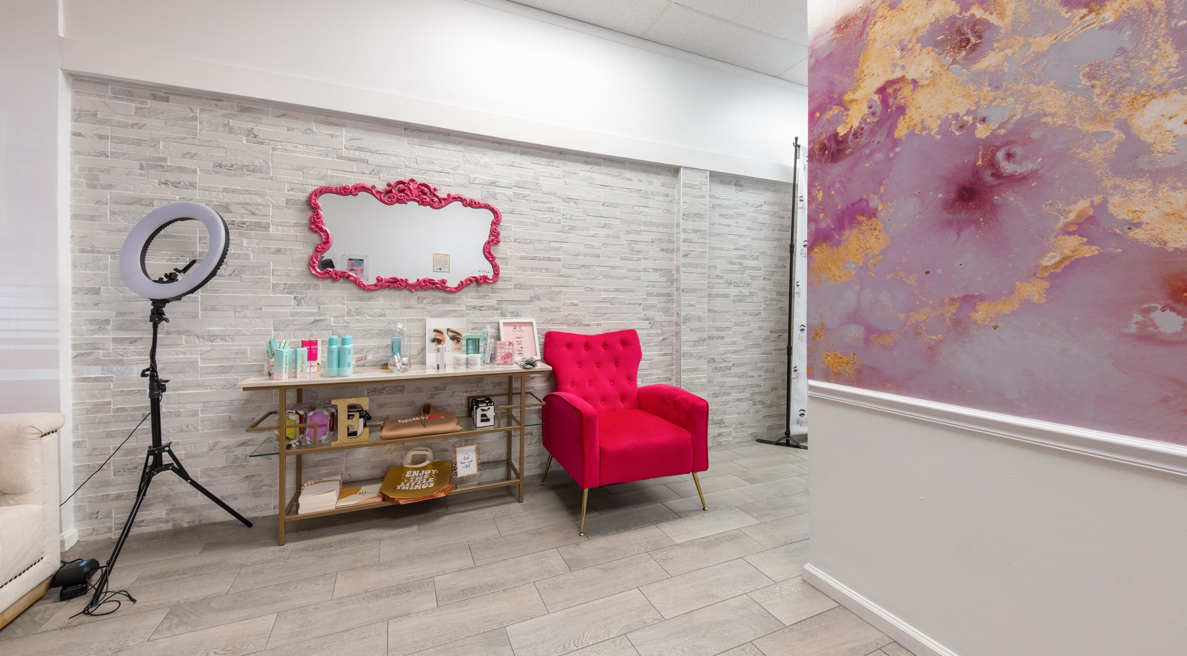 Chic glam corner at Eye Candy Lash and Brow Bar, Sarasota, Florida, US with a pink chair and mirror.