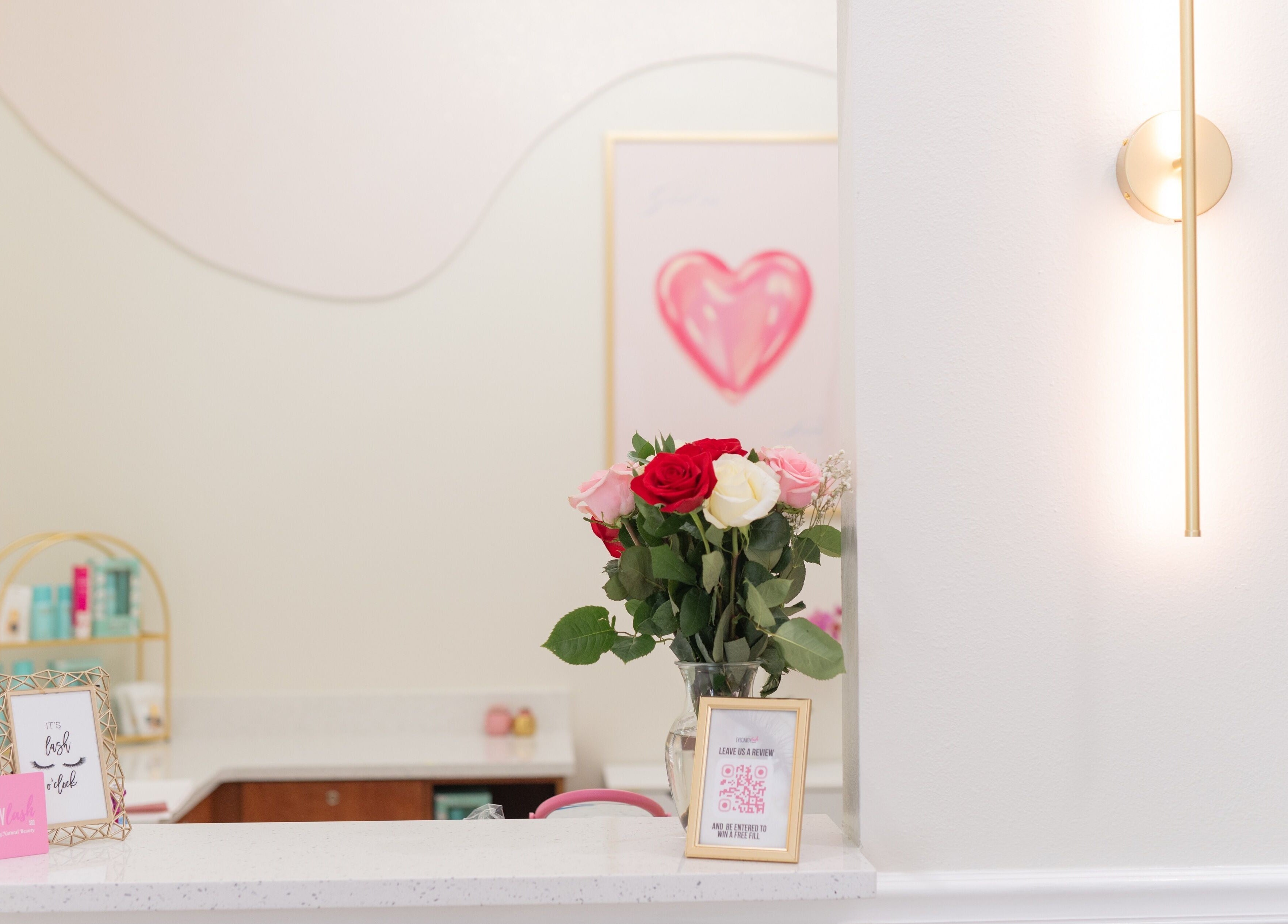 Eye Candy Lash and Brow Bar in Sarasota, Florida features a stylish reception with vibrant roses and elegant decor.