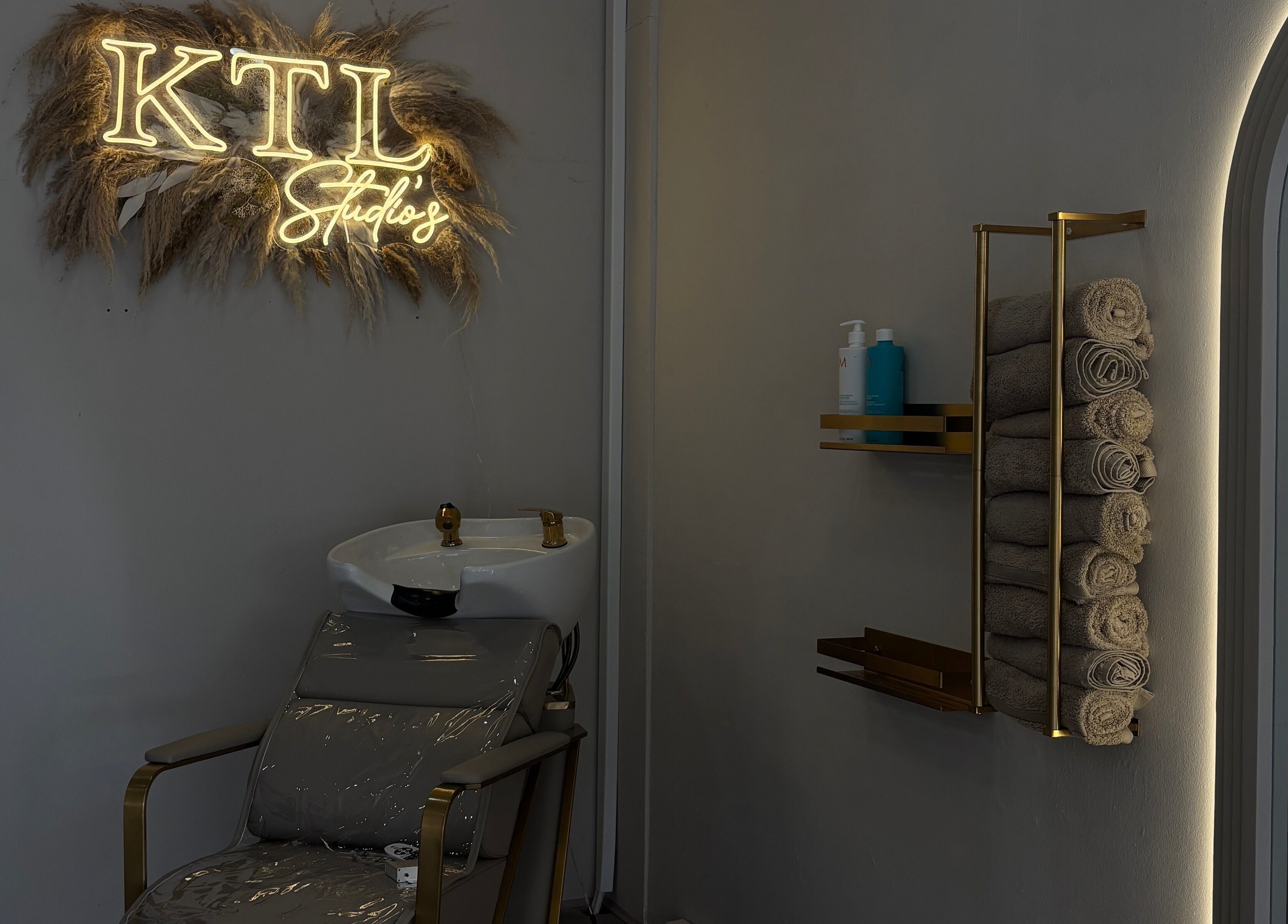 Luxurious wash station at Sculpted by Ashleigh, Moreton, England, GB with towels and modern decor.