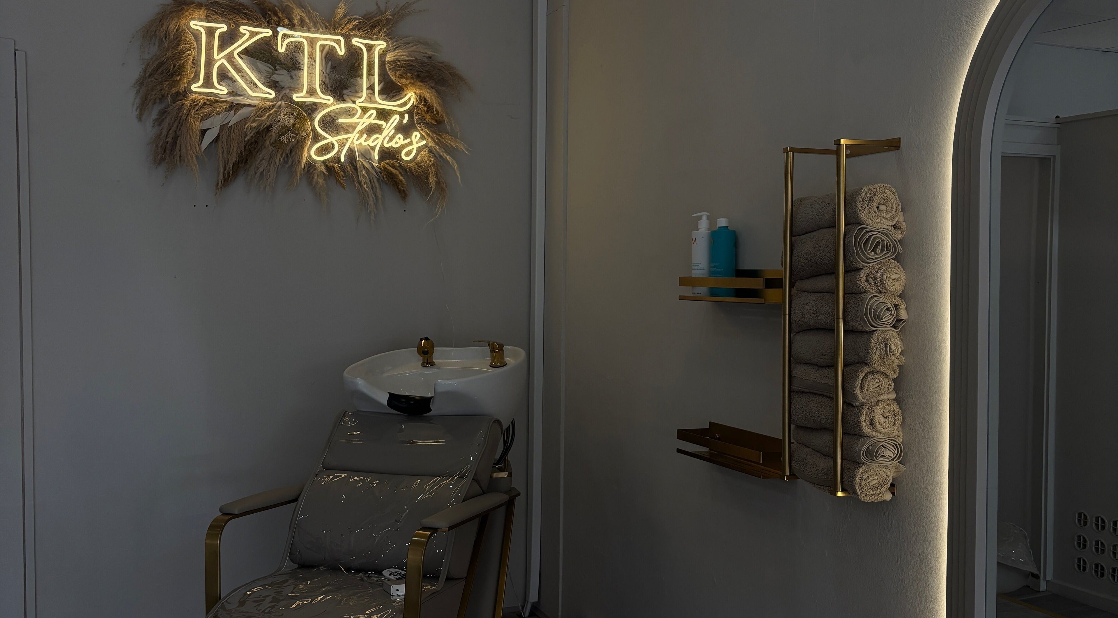 Luxurious wash station at Sculpted by Ashleigh, Moreton, England, GB with towels and modern decor.