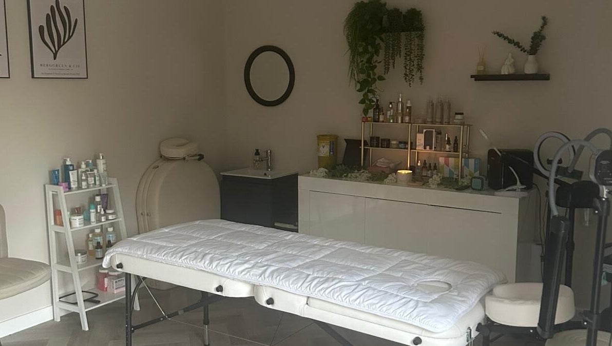 Cozy treatment room at James Aesthetics, Northampton, England, GB with massage table and skincare products.