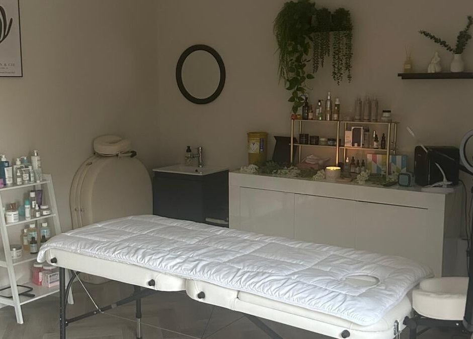 Cozy treatment room at James Aesthetics, Northampton, England, GB with massage table and skincare products.