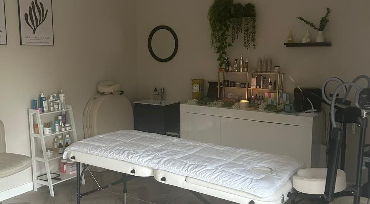 Cozy treatment room at James Aesthetics, Northampton, England, GB with massage table and skincare products.