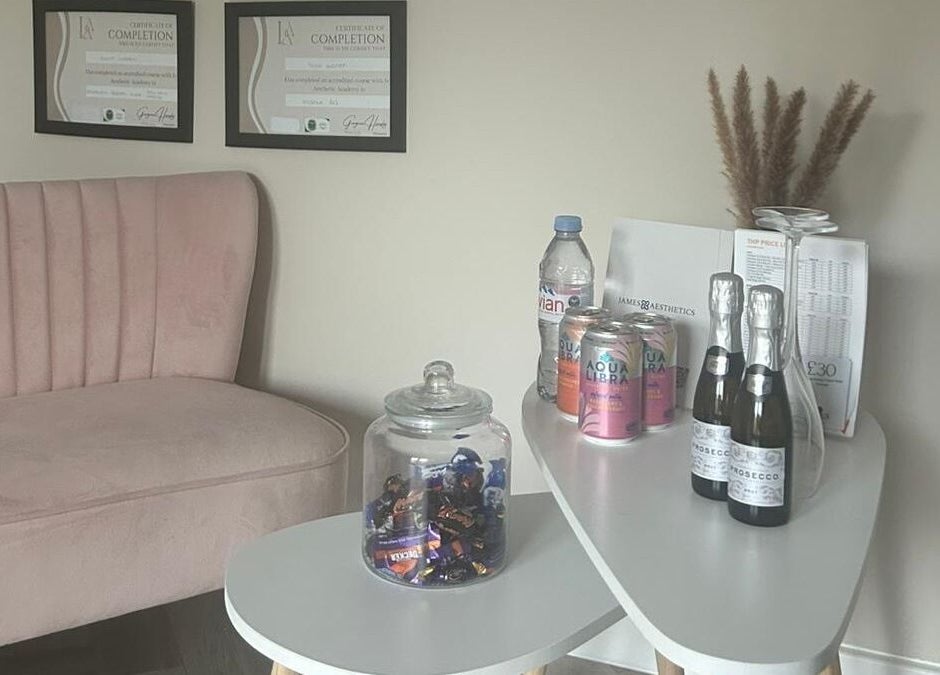 Inviting corner at James Aesthetics in Northampton, England, GB, featuring a pink sofa and refreshments.