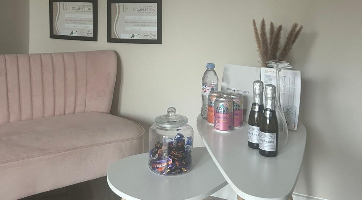 Inviting corner at James Aesthetics in Northampton, England, GB, featuring a pink sofa and refreshments.