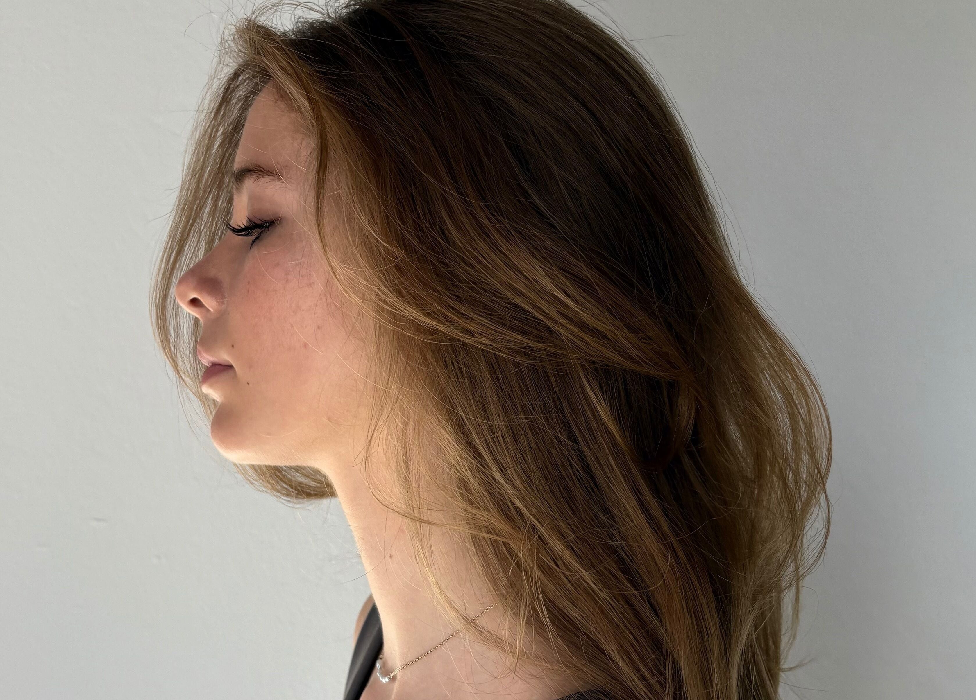 Side profile of woman showcasing elegant hairstyle at Simply, Gabriella in Newcastle, New South Wales, AU.