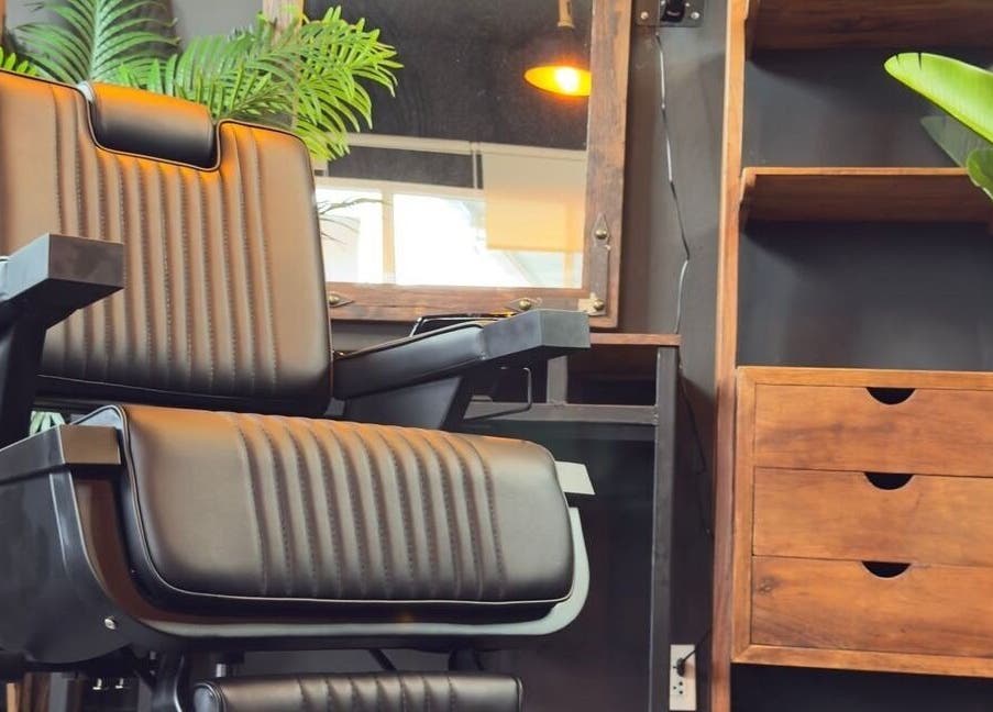 Modern barber chair at Wild Barber Boat Avenue in Choeng Thale, Phuket, TH, surrounded by lush greenery.