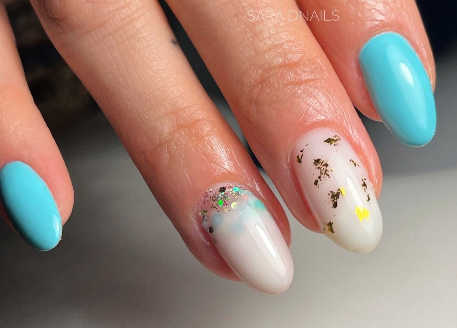 Manucure élégante avec vernis bleu et motifs dorés chez Sara D Nails à Meylan, Auvergne-rhône-alpes, FR.