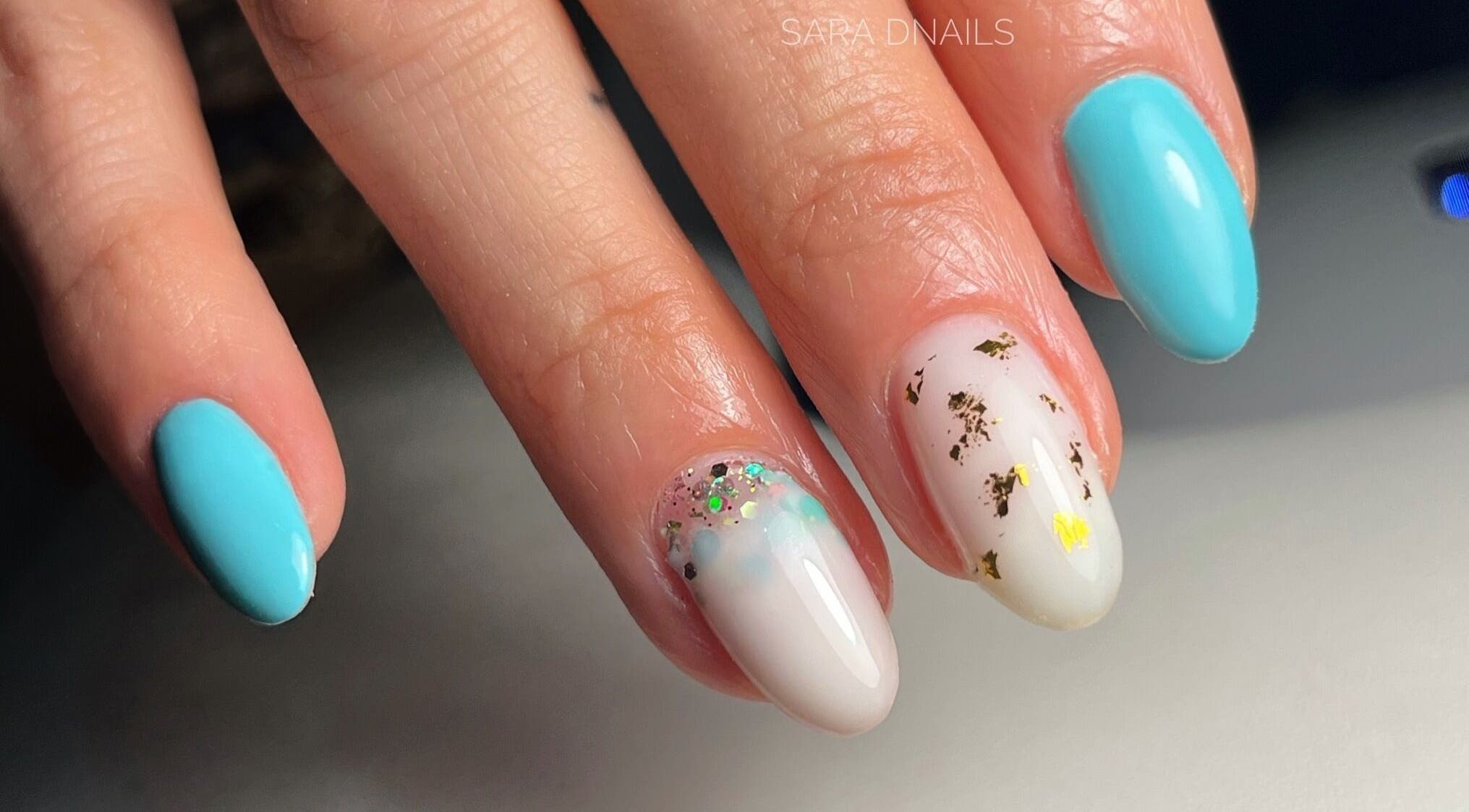 Manucure élégante avec vernis bleu et motifs dorés chez Sara D Nails à Meylan, Auvergne-rhône-alpes, FR.