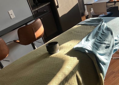 Comfortable massage table at Careful Touch spa in Detroit, Michigan, US, bathed in natural sunlight.